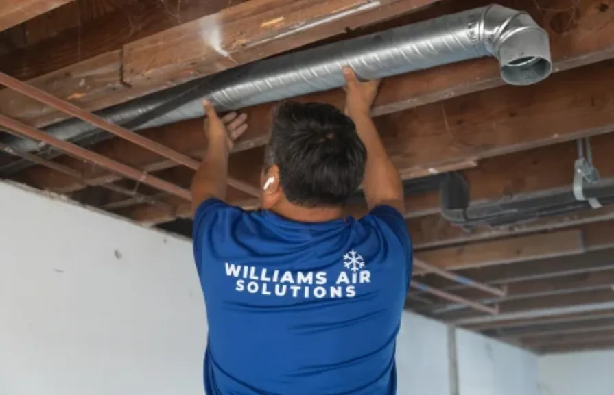 Williams Air Solutions technician servicing air conditioning equipment during a maintenance visit in Belleair, Florida