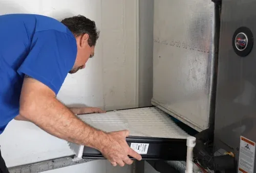 Williams Air Solutions technician changing an air filter at an air handler during a maintenance visit in Belleair